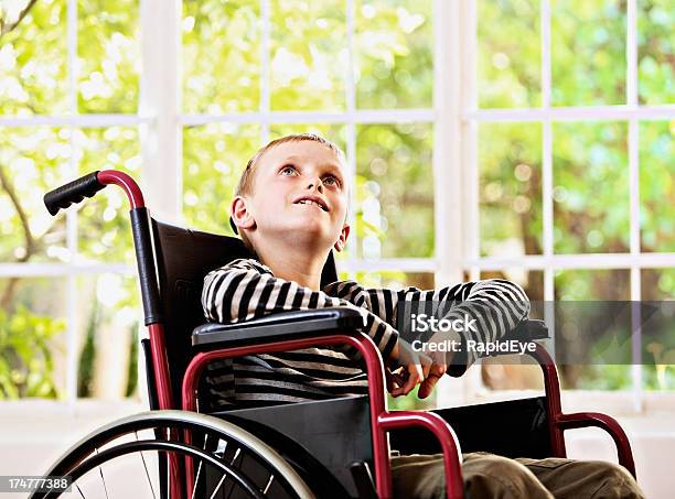 Foto de Pesaroso Menino Olha Longingly Em Cadeira De Rodas e mais fotos de stock de Paraplégico - Paraplégico, 8-9 Anos, Acidente