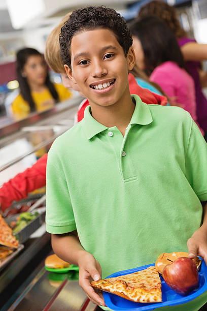 istock Happy boy in cafeteria lunch line with other students 174777871