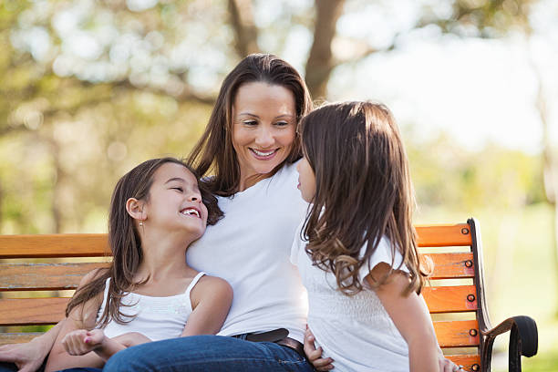 istock Smiling Woman With Daughters Sitting On Park Bench 174778195