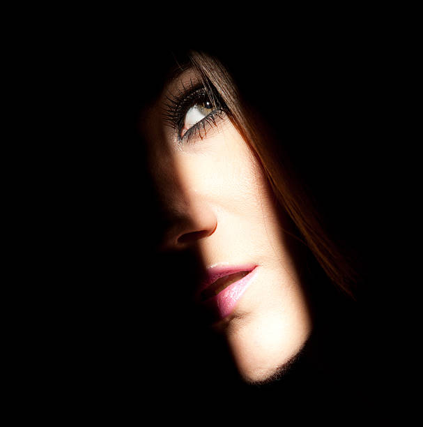 Sunlight falls on a woman's face through a small cranny