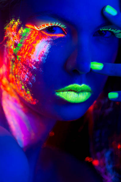 istock Women Portrait with Glowing Multi Colored makeup in black light 174778751
