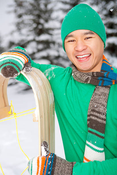 Smiling male holding sled