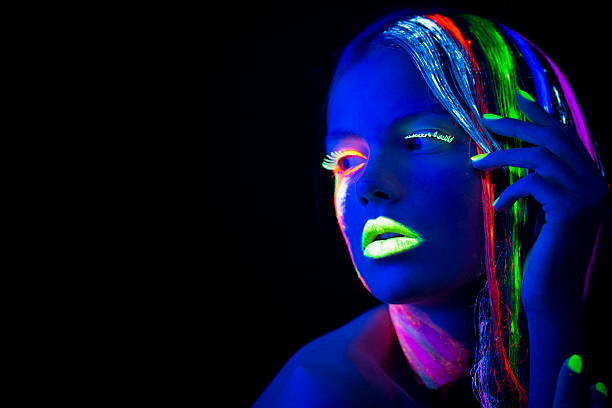 istock Women Portrait with Glowing Multi Colored makeup in black light 174778887