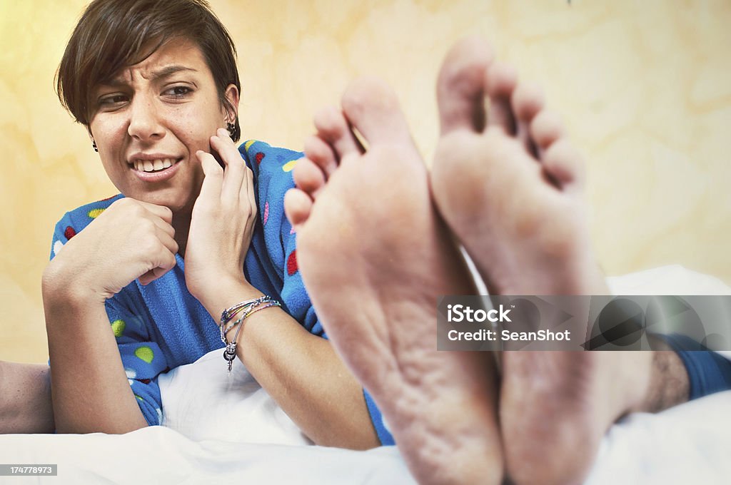 Jeune femme révoltant par copain de parfum pied - Photo de Odeur désagréable libre de droits