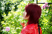 Smiling profile of young woman in garden.