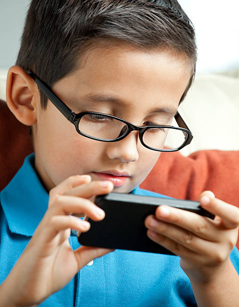 istock Child with eyeglasses playing on smartphone 174779074