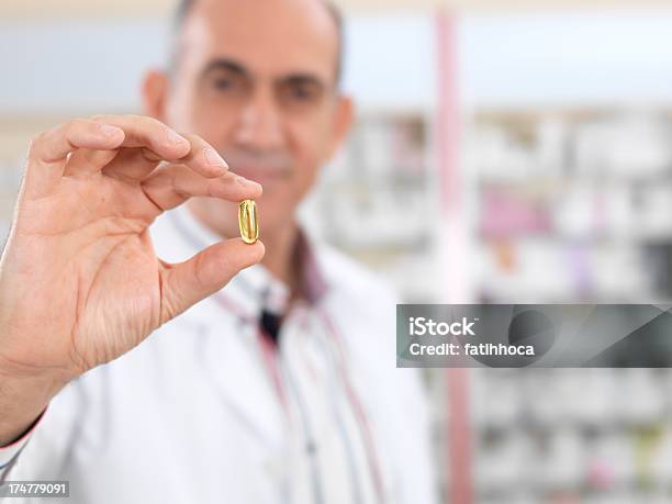 Yellow Pill Stock Photo - Download Image Now - Passing - Giving, Medicine, Fish Oil