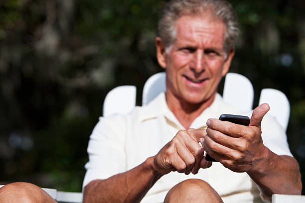 старший мужчина, используя мобильный телефон - sc0569 стоковые фото и изображения