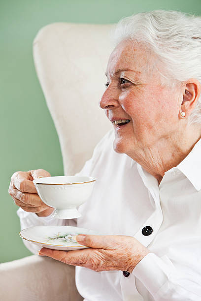 anziani donna con una tazza di tè - sc0570 foto e immagini stock
