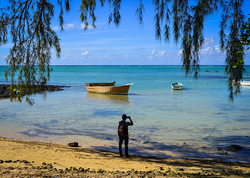 Malheureux, Mauritius - Jan 7, 2017. A man standing and looking at the blue sea on Mauritius Island.