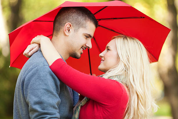 istock Young couple with umbrella in the park 174779729