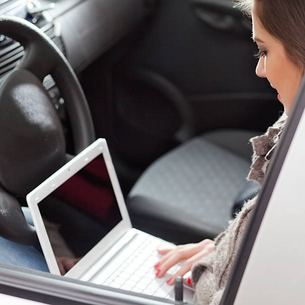 istock Young woman typing on laptop in a car 174779821