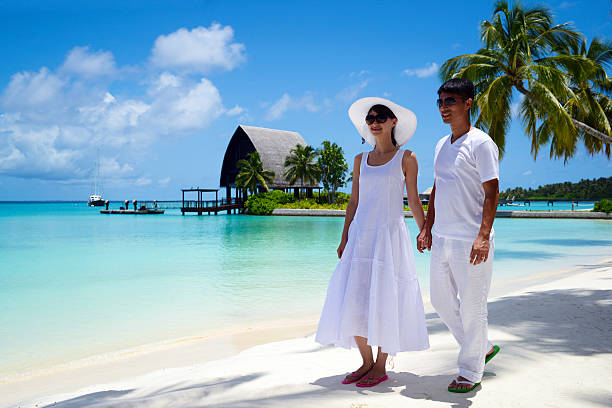 casal jovem caminhando na praia - mulher feliz desfrutando de praia exótica no verão tropical de azul - fotografias e filmes do acervo