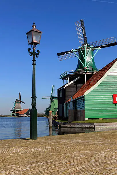 Photo of collection of historic windmills in a row at Zaanse Schans