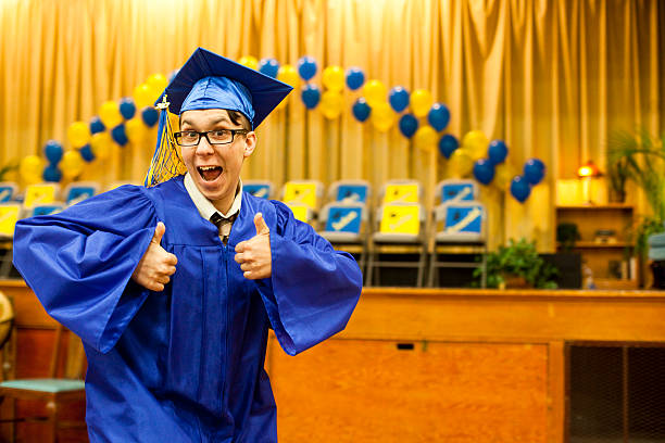 高校卒業親指を立てる若い男性 - thumbs up child success winning ストックフォトと画像