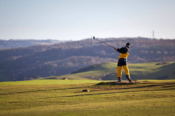 golfista w zimowe ubrania drving z tee - sms3864 zdjęcia i obrazy z banku zdjęć