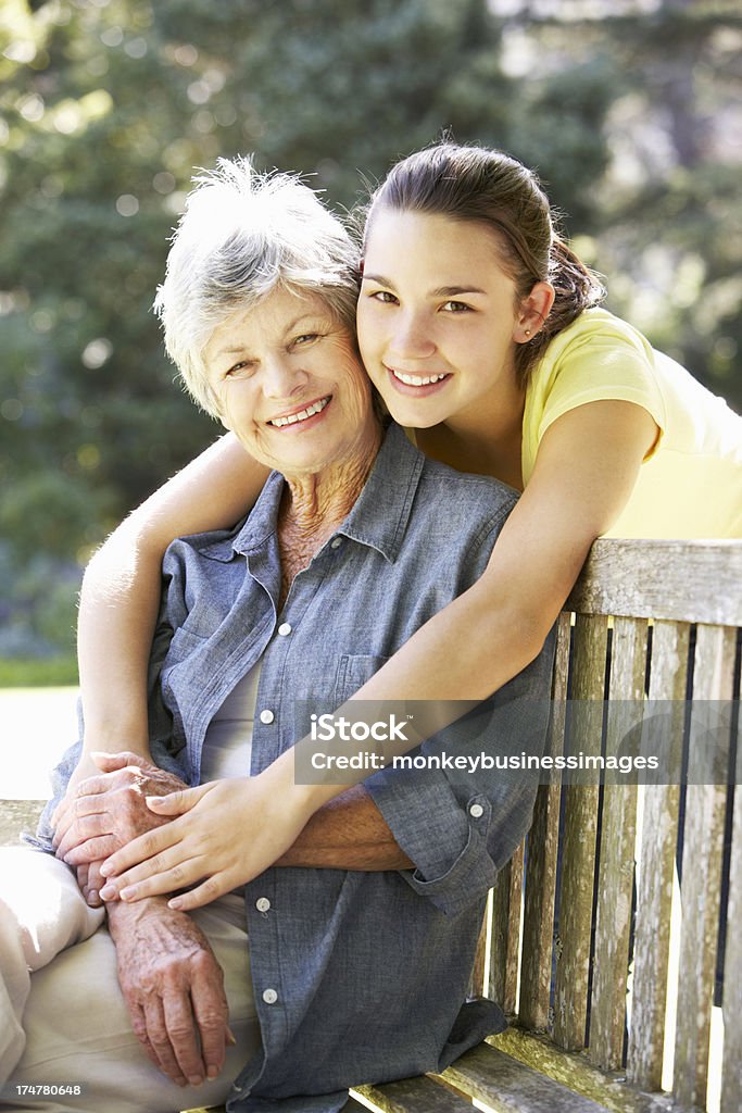Grand-mère et petite-fille assis sur un banc jeune ensemble - Photo de Adolescent libre de droits