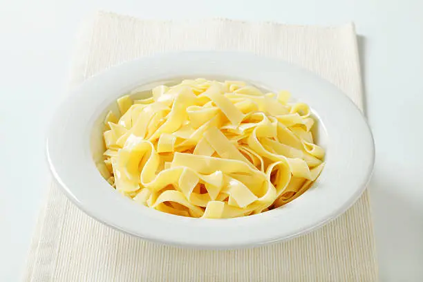boiled pasta tagliatelle in a white plate