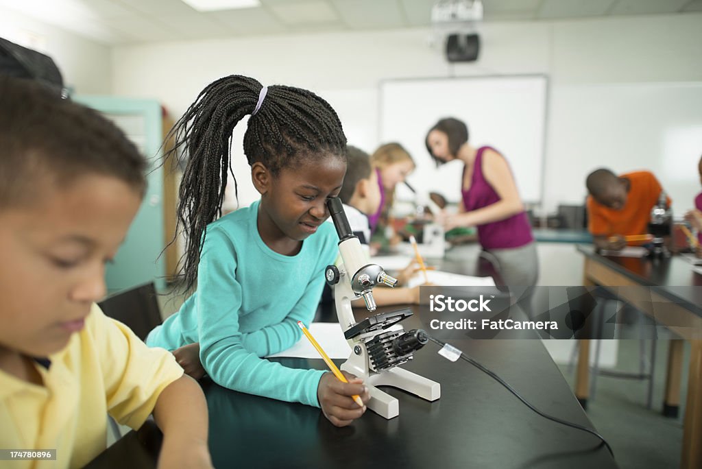 Jovem estudante com um microscópio. - Foto de stock de 6-7 Anos royalty-free