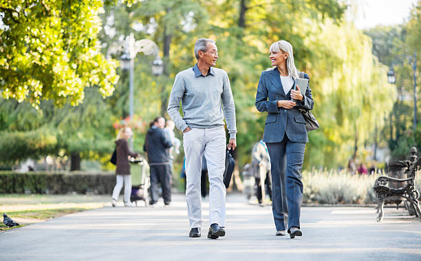 istock Two businesspeople taking a walk in park. 174780980