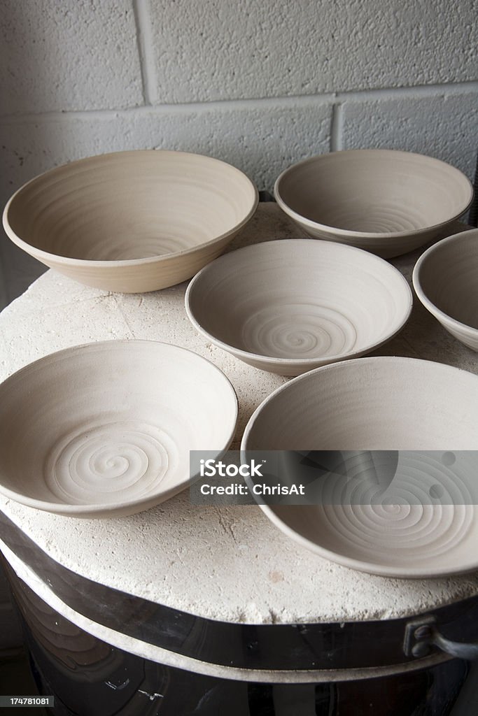 Pottery studio Work in progress standing on the top of the kiln in a ceramics artists home pottery studio. Stoneware bowls, turned, dried and ready to fire. Art And Craft Stock Photo