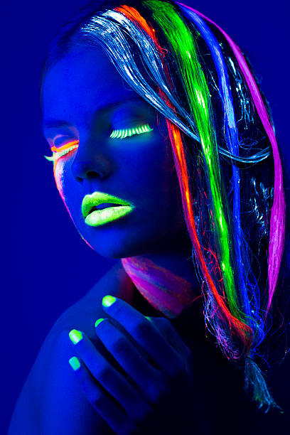istock Women Portrait with Glowing Multi Colored makeup in black light 174782410