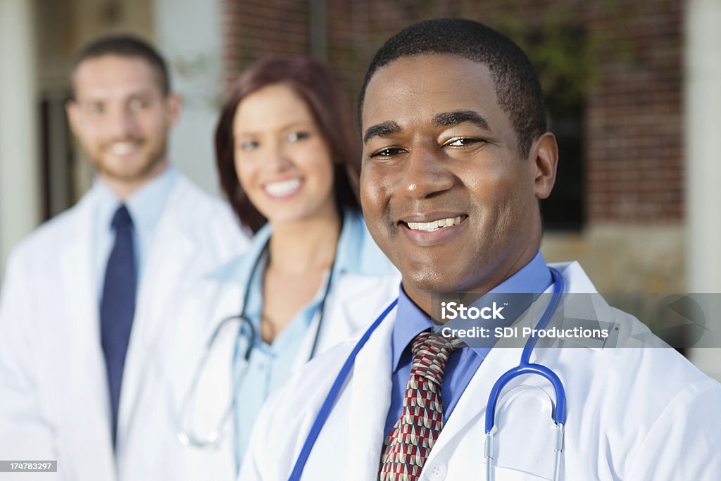 Freundlicher Arzt mit Mitarbeitern im Krankenhaus - Lizenzfrei Afrikanischer Abstammung Stock-Foto