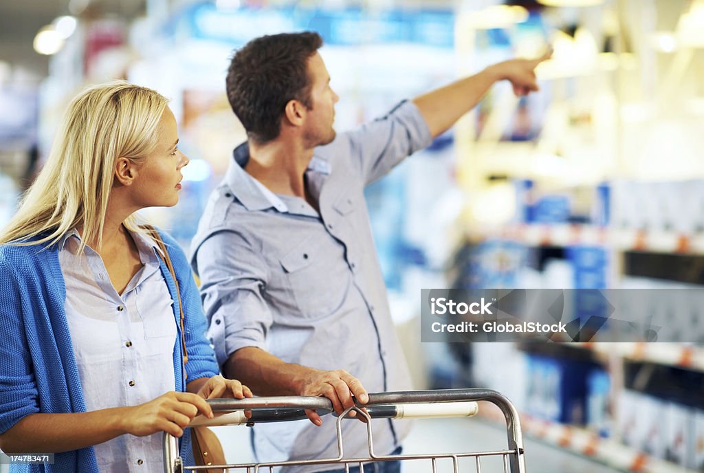 Maybe it's in that aisle over three? A young couple doing some saturday shopping 20-29 Years Stock Photo