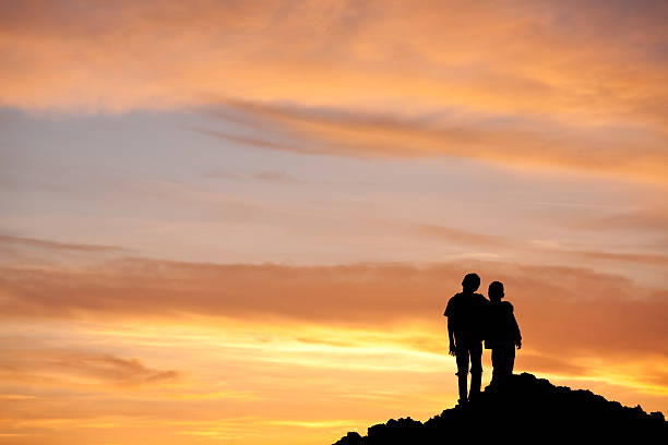 istock Silhouette of Two Young Boys Hugging on a Hill 174783500