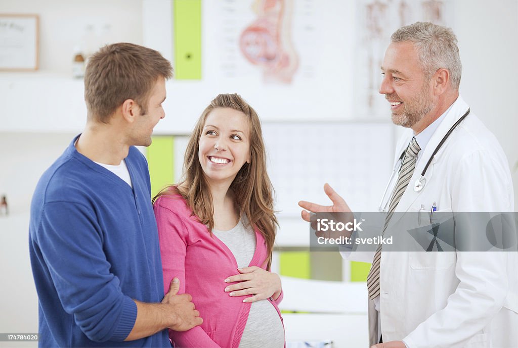 Donna incinta con il marito in ambulatorio medico. - Foto stock royalty-free di Accudire