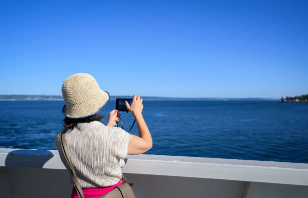 женщина фотографирует на смартфон на пароме в заливе эллиотт. сиэтл. штат вашингтон. - ferry seattle washington state cruise ship стоковые фото и изображения