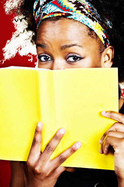 istock Eyebrows raised, cute woman peeps over book cover 174784511
