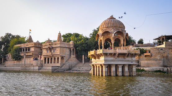 Ancient temple with Lake Gadisar in Jaisalmer, India. Gadsisar Lake is an artificial lake built by Raja Rawal Jaisal.