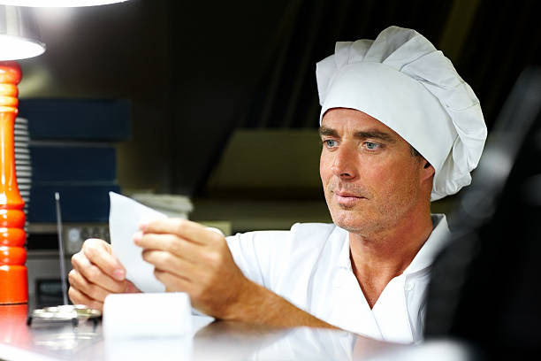 istock Male chef at restaurant reading order 174785075