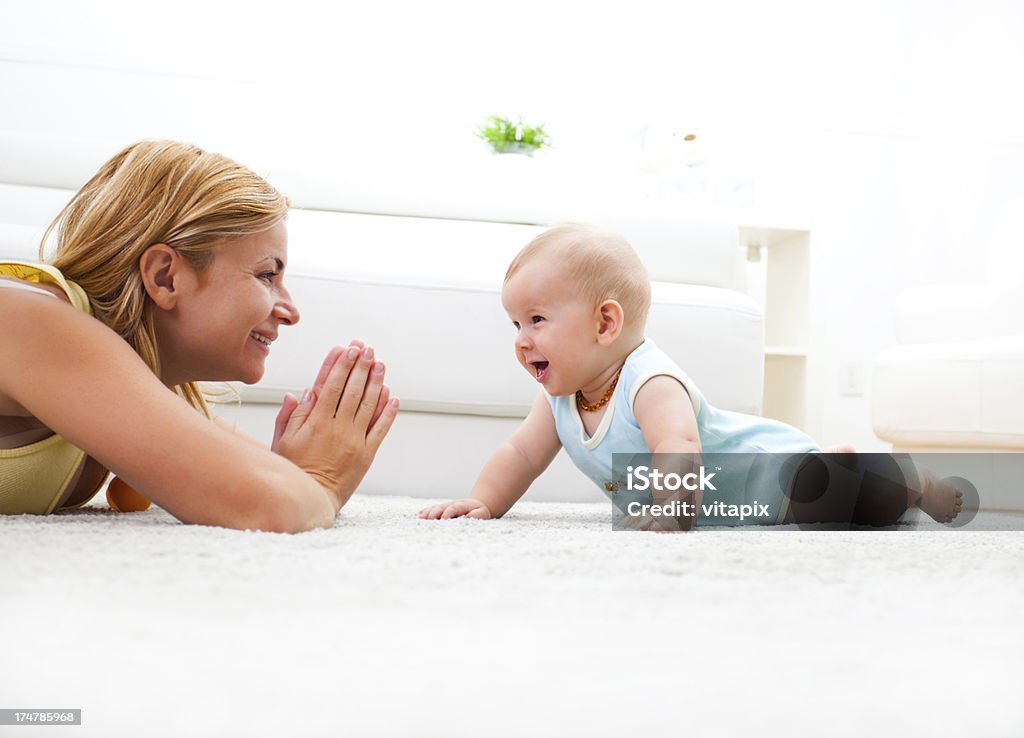 Madre y bebé jugando en la sala de estar de la suite white - Foto de stock de Moqueta libre de derechos