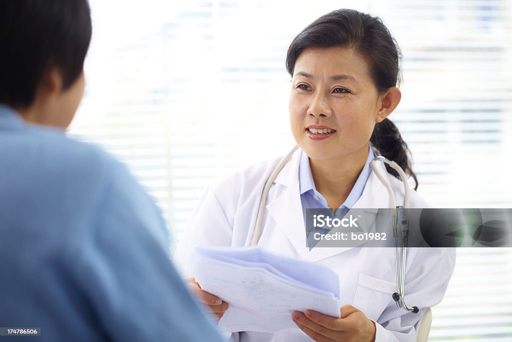 mature femme médecin parlant à un patient au bureau - Photo de 45-49 ans libre de droits