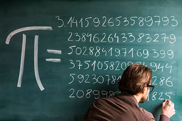 Photo of Teacher, student, scientist hand writing Pi numbers on green chalkboard