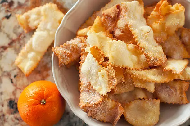 Sweet crisp pastry shaped into ribbons fried and sprinkled with sugar.