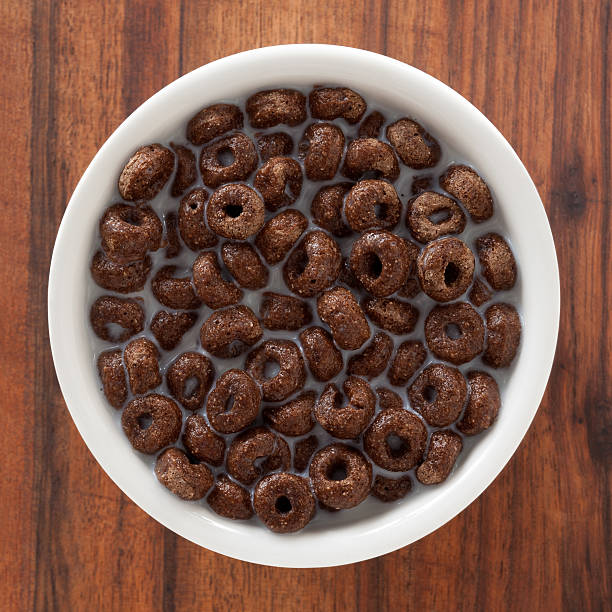 Top view of white bowl full of chocolate cereal rings