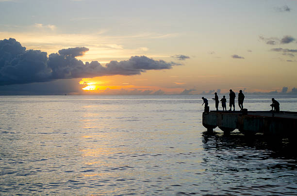 istock men and boys fishing silhouetted on jetty 174788671