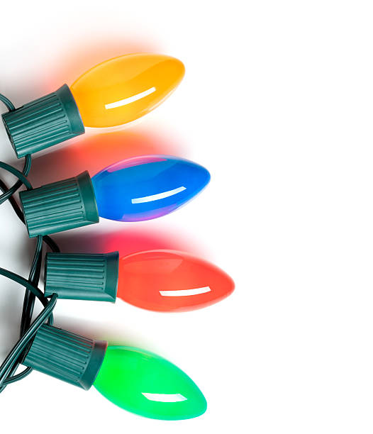 Four old fashioned Christmas lights over a white background.