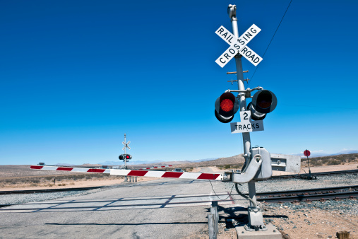 Level crossing barrier with red signal on Cuttof Rd, Death valley National Park, California, Western USA.