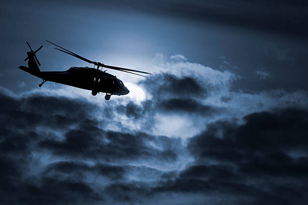 Military Helicopter Silhouette Against the Moon stock photo