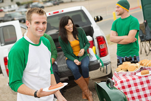istock Group of college students cooking out at tailgate party 174790126