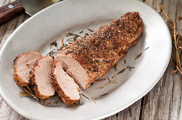 Pork Tenderloin Pork tenderloin on a platter with knife rosemary and peppercorns.  Please see my portfolio for other food related images. pork stock pictures, royalty-free photos & images