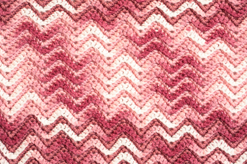 Crochet blanket in pink and white with chevron pattern