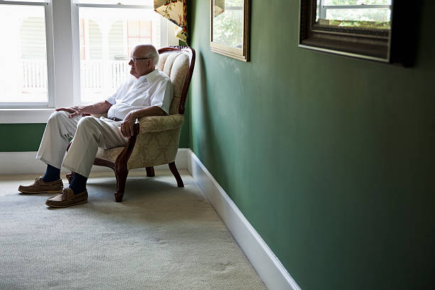 istock Senior man staring out a window 174791229