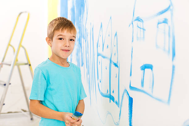 istock Boy painted a house on the wall 174791600