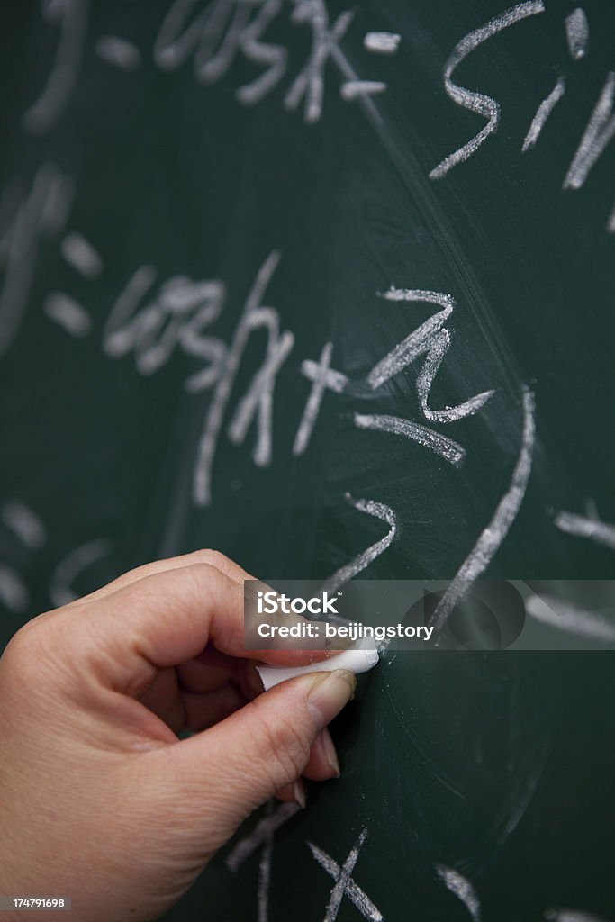 Persona di scrivere equazione matematica su chalkboard - Foto stock royalty-free di Corso di matematica