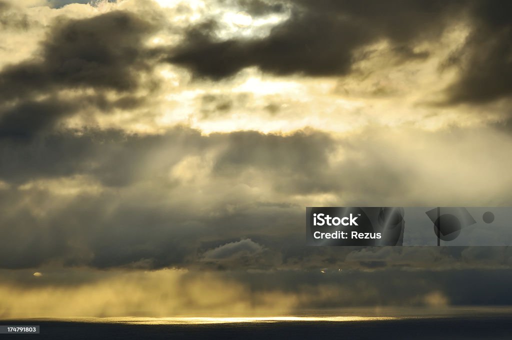 Sunbeams em céu nublado acima do mar - Foto de stock de Acima royalty-free